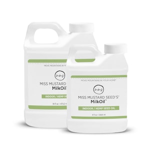 May include: Two white plastic jugs of Miss Mustard MilkOil. The larger jug is labeled 16 fl oz / 473.2 ml, and the smaller jug is labeled 8 fl oz / 236.6 ml. Both jugs have a green stripe and the text "INDOOR / HEMP SEED OIL".