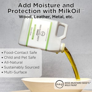 May include: A white container of Miss Mustard Seed's MilkOil is pouring a stream of oil into a bowl. The container has green and white labels with text that reads "Add Moisture and Protection with MilkOil". The text also says "Food-Contact Safe" and "Multi-Surface".
