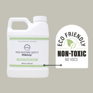 Pode incluir: Frasco de pl&aacute;stico branco de MilkGrip da Miss Mustard Seed, um agente de liga&ccedil;&atilde;o para interiores. O frasco tem uma pega e uma tampa branca. O r&oacute;tulo inclui o texto "16 fl oz / 473,2 ml" e "Eco Friendly Non-Toxic".