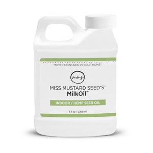 May include: White plastic bottle of Miss Mustard Seed's MilkOil. The label includes the text "MOVE MOUNTAINS IN YOUR HOME" and "INDOOR / HEMP SEED OIL". The bottle contains 8 fl oz / 236.6 ml of product.