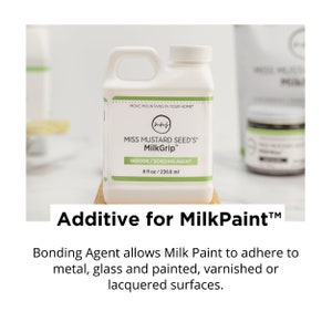 Pode incluir: Frasco de pl&aacute;stico branco de MilkGrip da Miss Mustard Seed, um agente de liga&ccedil;&atilde;o para interiores para MilkPaint. O frasco tem uma pega e uma tampa branca. O texto "236,6 ml" &eacute; vis&iacute;vel.
