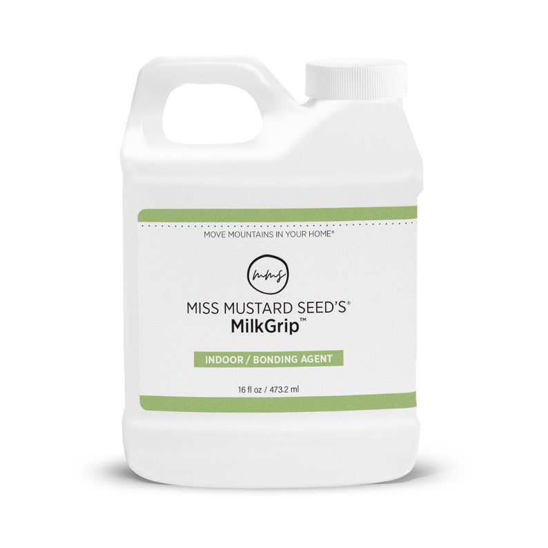 Pode incluir: Um recipiente de pl&aacute;stico branco de MilkGrip da Miss Mustard Seed, um agente de liga&ccedil;&atilde;o para interiores. O recipiente tem uma pega e uma tampa de rosca branca. O r&oacute;tulo inclui o texto "MOVE MOUNTAINS IN YOUR HOME" e "473,2 ml".