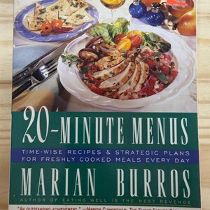 May include: A cookbook titled "20-Minute Menus" by Marian Burros. The cover features a meal with sliced chicken, tomatoes, and salad. The book's title is in large white letters on a green background. It promises time-wise recipes for freshly cooked meals.