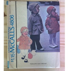 May include: A vintage McCall's 4806 sewing pattern for toddler coats and hats. The cover shows illustrations of children in coats and hats in pink, grey, and red. The text on the cover reads "Toddler Size 2" and "Toddlers' Coat and Hat".