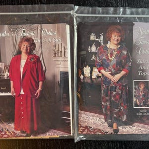 Könnte beinhalten: Zwei versiegelte Plastikverpackungen mit Schnittmustern für Damenbekleidung. Eine Packung zeigt einen roten Anzug mit dem Text "Martha's Favorite Clothes The Soft Suit". Die andere Packung zeigt ein Rock- und Top-Set mit dem Text "Martha's Favorite Clothes Skirts And Tops."