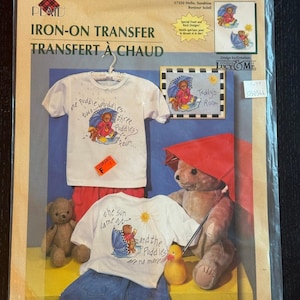 Puede incluir: Un paquete de transferencia de planchado Plaid con un diseño de oso de peluche bajo un paraguas. El paquete incluye una camiseta blanca con el texto "one puddle, two puddles, three puddles, four..." y una segunda camiseta con el texto "the sun came out and the puddles are no more."