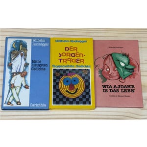 Pode incluir: Três livros antigos com capas coloridas. Os livros são intitulados "Meine lustigsten Gedichte", "DER SORGEN-TRAGER" e "WIA AJOAHR IS DAS LEBN". As capas apresentam ilustrações e texto em alemão.