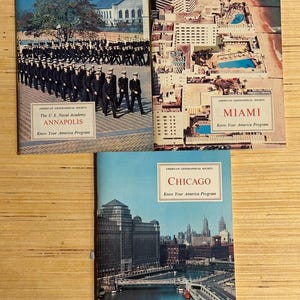 Puede incluir: Tres guías de viaje vintage de la American Geographical Society. Las portadas presentan imágenes de Annapolis, Miami y Chicago. Cada guía tiene un título y la frase "Know Your America Program". La guía de Annapolis muestra la Academia Naval de EE. UU.
