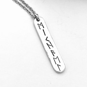 Pewter bar with rounded ends and hammered edges hangs from 3mm oval link stainless steel chain. It is displayed on a white background. Bar is 1cm wide and 6mm viking runes have been stamped vertically to form a name.