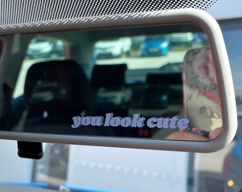 Puede incluir: Un espejo retrovisor con una pegatina blanca que dice "you look cute".