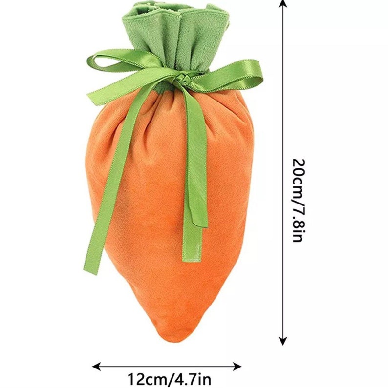 May include: A carrot-shaped drawstring bag made of orange velvet with green velvet leaves at the top. The bag is tied with a green ribbon. The bag measures 20cm/7.8in tall and 12cm/4.7in wide.