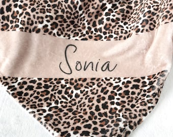 May include: A soft, pink and brown leopard print throw blanket with the name "Sonia" embroidered on a pink stripe.