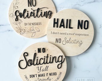 Könnte beinhalten: Drei runde Holzschilder mit schwarzem Text. Das obere Schild sagt "NO Soliciting TRY THE NEIGHBORS." Das mittlere Schild sagt "HAIL NO I don't need a roof inspection NO Soliciting." Das untere Schild sagt "NO Soliciting Y'all DON'T MAKE IT WEIRD Seriously FAMILY, FRIENDS, NEIGHBORS & DELIVERIES WELCOME."