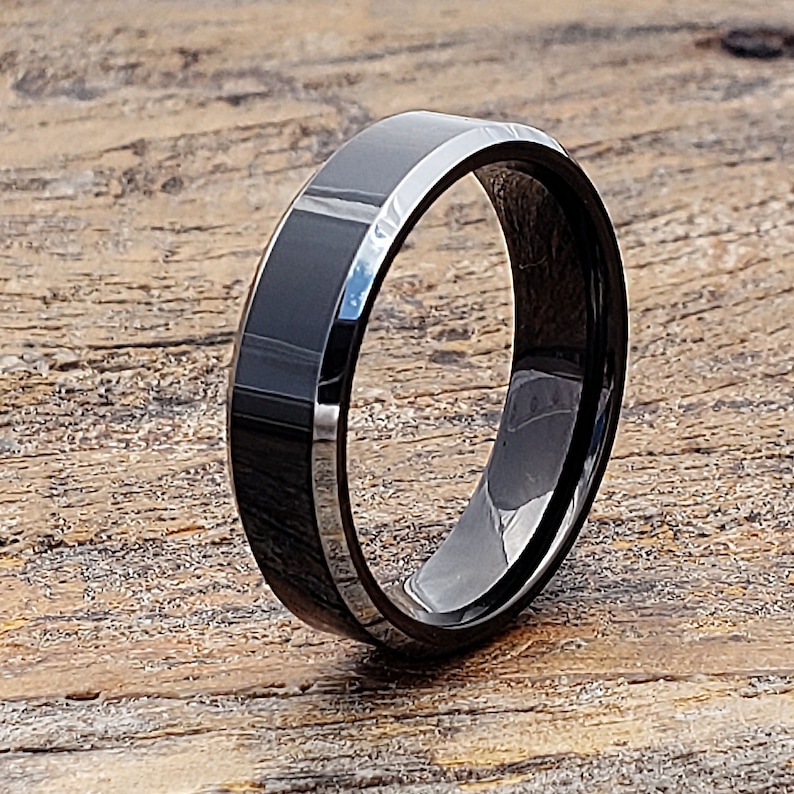 May include: A black tungsten carbide ring with a beveled edge and a polished finish.