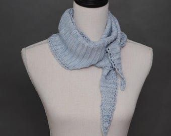 May include: A light blue knitted scarf with a delicate lace pattern. The scarf is draped around a white mannequin's neck.