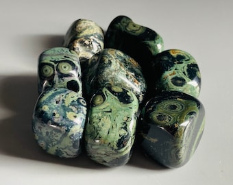 May include: A collection of tumbled green and black ocean jasper stones. The stones have a swirling pattern of green, black, and white.