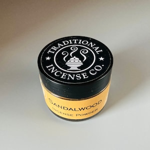 May include: A black jar with a white label that says "Traditional Incense Co." and a small image of an incense burner. The label also says "Sandalwood Incense Powder".