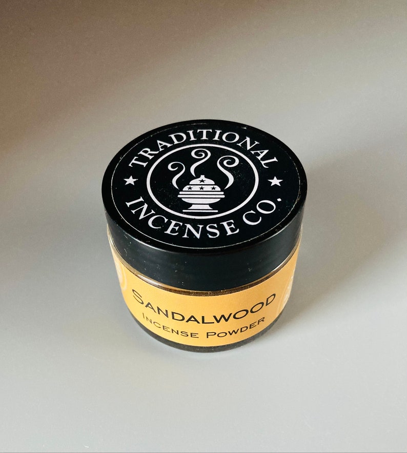 May include: A black jar with a white label that says "Traditional Incense Co." and a small image of an incense burner. The label also says "Sandalwood Incense Powder".