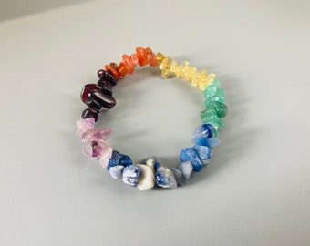 Op de afbeelding: Een regenboogkristallen armband met verschillende gekleurde stenen, waaronder rood, oranje, geel, groen, blauw en paars.