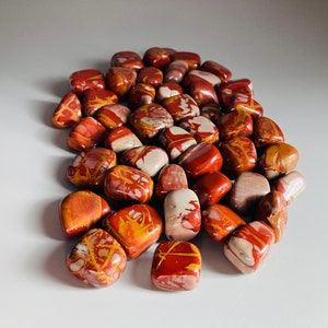 Peut inclure: Une collection de pierres roulées de couleur rouge, blanche et brune. Les pierres sont lisses et présentent une variété de motifs.