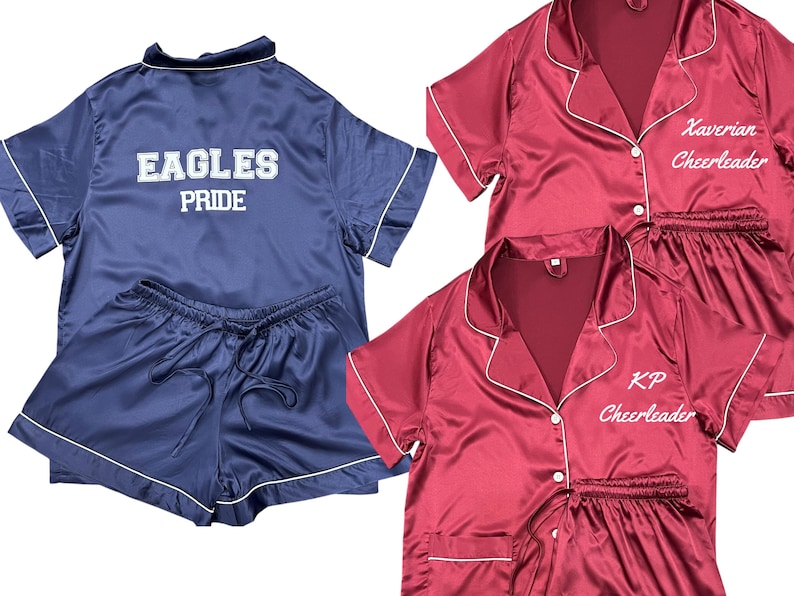 May include: Navy blue satin pajama set with white trim. The top has "EAGLES PRIDE" embroidered on the back. Two maroon satin pajama sets with white trim are also shown, one with "Xaverian Cheerleader" and the other with "KP Cheerleader" embroidered.