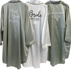 May include: Three satin robes in different colors, with the words "Maid of Honor", "Bride", and "Bridesmaid" and dates printed on the back.
