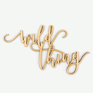 Peut inclure: Une pancarte en bois avec les mots "wild thing" écrits en cursive.