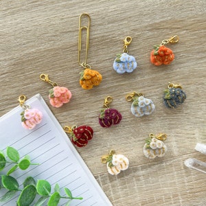 Op de afbeelding: Assortiment van 10 vilten bloemencharms met gouden accenten. Elke charm heeft een gouden karabijnhaak om te bevestigen aan een tas, sleutelhanger of ander item.