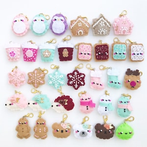 May include: A collection of 30 felt Christmas ornaments with various designs, including penguins, gingerbread houses, snowflakes, reindeer, hedgehogs, snowmen, and bears. The ornaments are all attached to gold keychains.