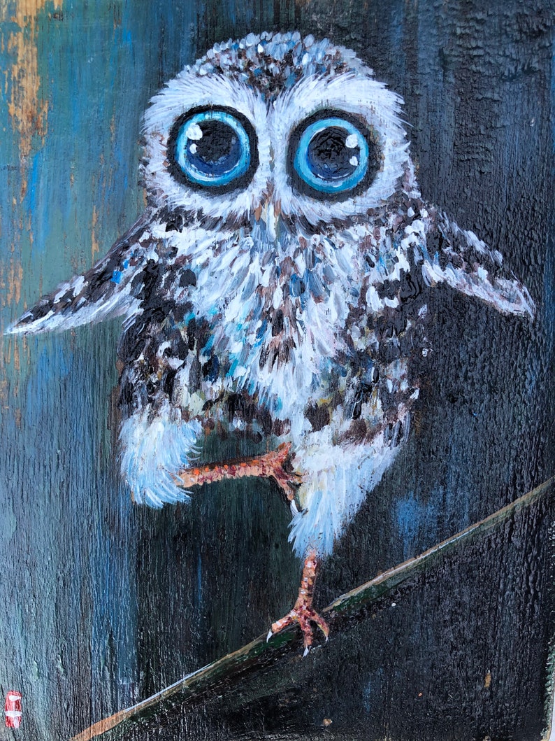 Puede incluir: Una pintura caprichosa de un b&uacute;ho con grandes ojos azul brillante. El b&uacute;ho est&aacute; posado en una rama, con las alas ligeramente extendidas. La obra presenta un fondo texturizado con tonos de azul y negro, creando un contraste llamativo.
