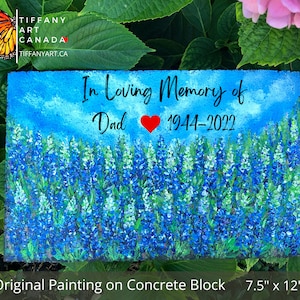 May include: A hand-painted concrete block memorial with a bluebonnet flower field, a blue sky, and the text "In Loving Memory of Dad 1944-2022". The block measures 7.5 inches by 12 inches.