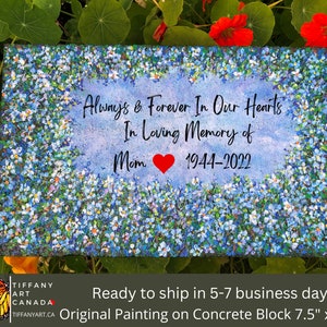 May include: A blue and white floral painting on a concrete block with the text "Always & Forever In Our Hearts In Loving Memory of Mom 1944-2022".