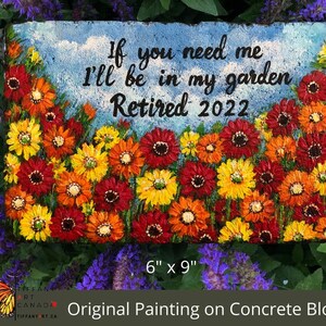 May include: A 6-inch by 9-inch concrete block painted with a garden scene of red, orange, and yellow flowers. The text "If you need me I'll be in my garden Retired 2022" is painted on the block.