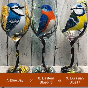 May include: Three hand-painted wine glasses featuring detailed bird portraits: a Blue Jay, an Eastern Bluebird, and a Eurasian Blue Tit. Each glass showcases a different bird species with vibrant colors and delicate floral accents. The text on the image says "One Glass Only, Original Painting."