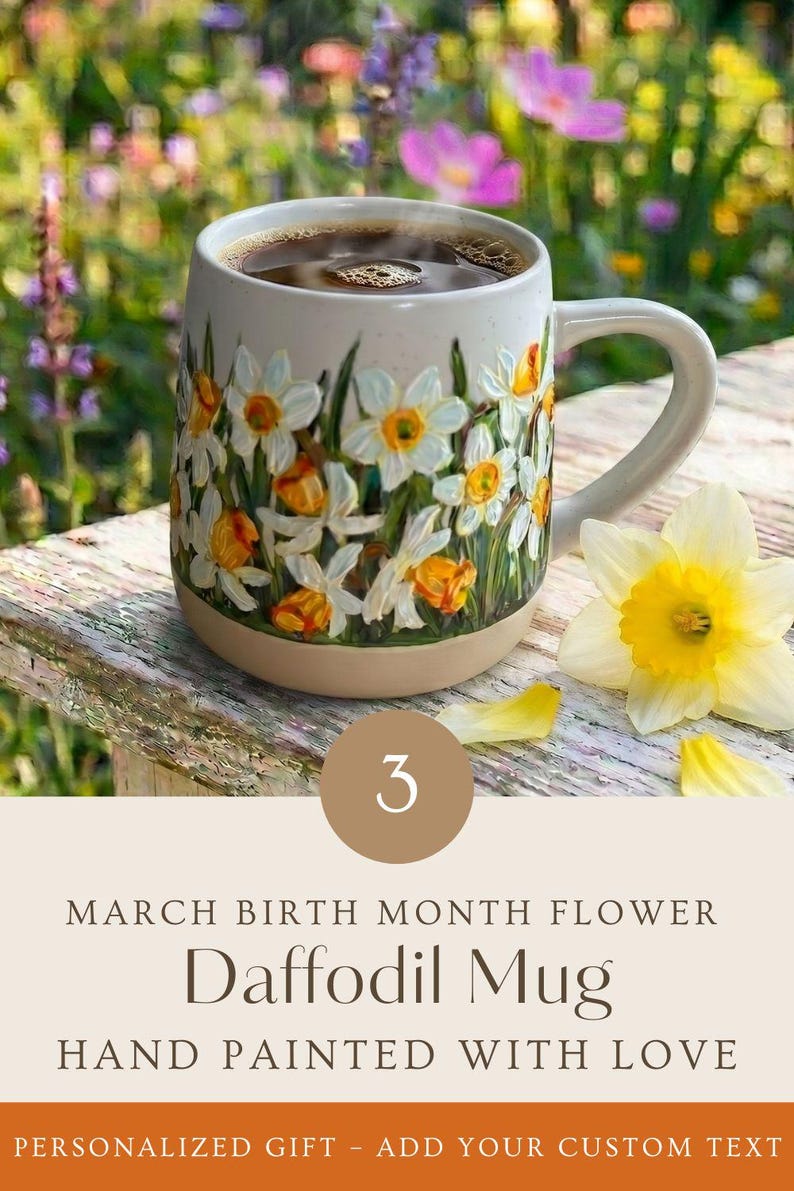 May include: A ceramic mug featuring a hand-painted design of white and yellow daffodils with green stems. The mug contains dark liquid and is accompanied by a single yellow daffodil flower. Text on the image reads: 3 MARCH BIRTH MONTH FLOWER Daffodil Mug HAND PAINTED WITH LOVE PERSONALIZED GIFT - ADD YOUR CUSTOM TEXT.