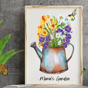 May include: Watercolor print of a watering can overflowing with colorful flowers, including yellow daffodils, white blossoms, and purple morning glories. A hummingbird hovers nearby. The words "Mama's Garden" are written below the watering can. The print is in a wooden frame.