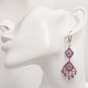 K&ouml;nnte beinhalten: Lila und rosa Perlen-Ohrringe mit geometrischem Design. Die Ohrringe sind silberfarben und haben einen Hakenverschluss.