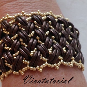 May include: A brown and gold woven bracelet with a decorative beaded edge. The bracelet is worn on a person's wrist.