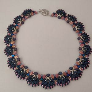 May include: A dark blue and pink beaded necklace with a silver clasp. The necklace features a repeating pattern of small, dark blue beads and larger, pink beads.