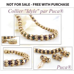 Könnte beinhalten: Eine goldene Halskette mit einem Perlenmuster, die einen Verschluss mit einem dekorativen Ende hat. Die Halskette ist mit "Collier "Idyle" par Puca®" beschriftet.