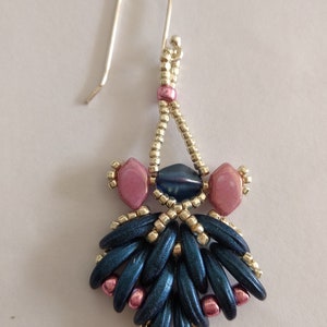 May include: A pair of dangle earrings with a silver hook, blue and pink beads, and a silver bead accent.