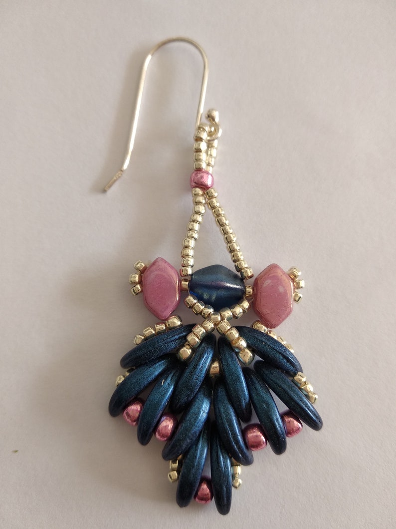 May include: A pair of dangle earrings with a silver hook, blue and pink beads, and a silver bead accent.