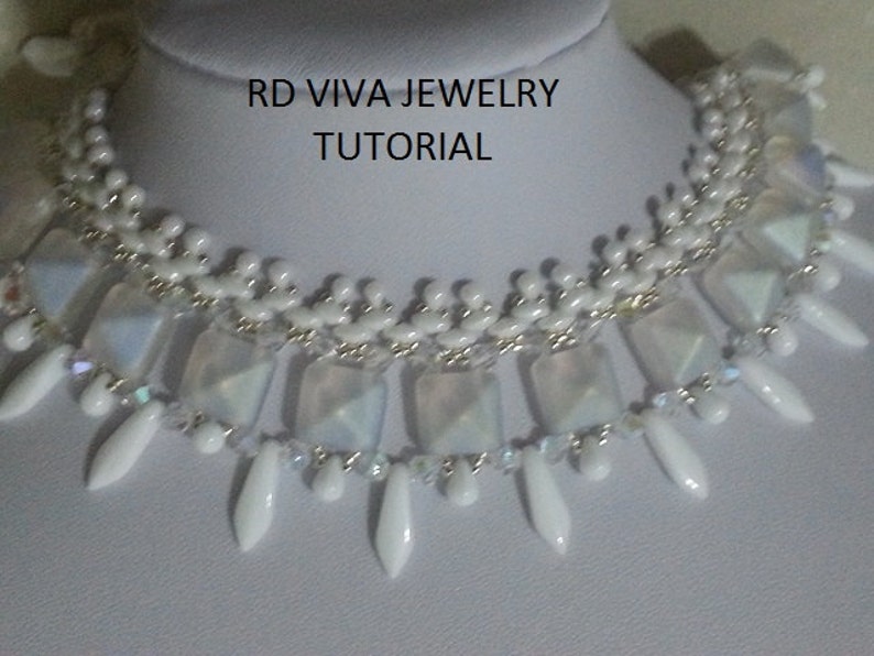 Pu&ograve; includere: Una collana di perline bianche con perline quadrate iridescenti e perline bianche a forma di lacrima. La collana &egrave; su un manichino bianco. Il testo "RD VIVA JEWELRY TUTORIAL" &egrave; sul manichino.