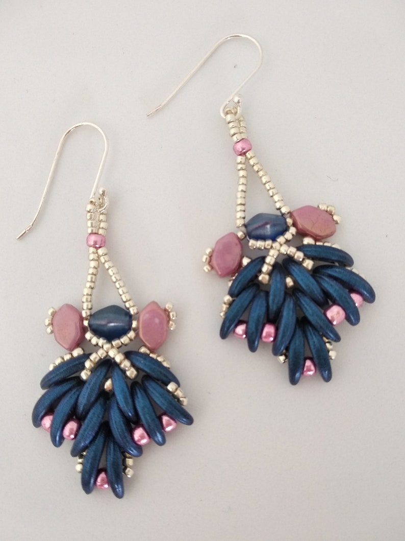 May include: A pair of dangle earrings with a silver hook and a blue and pink beaded design.