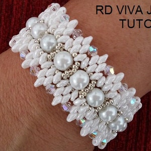 Może przedstawiać: Biała bransoletka z koralików z perłowymi akcentami. Bransoletka jest na nadgarstku osoby. RD Viva Jewelry Tutorial.