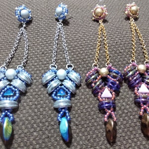 May include: Four pairs of beaded dangle earrings. Two pairs feature silver-toned chains and blue and silver beads. The other two pairs have gold-toned chains and purple, pink, and brown beads. Each earring has a unique design.
