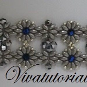 May include: A silver and blue beaded bracelet with a floral design. The bracelet is made with small seed beads and features a repeating pattern of silver and blue beads.