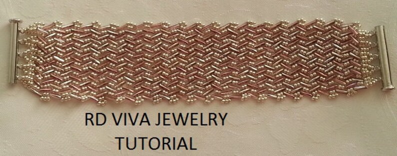 Puede incluir: Un primer plano de una pulsera de cuentas rosa y plateada con un patr&oacute;n tejido. La pulsera est&aacute; unida a tapas de extremo plateadas. El texto "RD VIVA JEWELRY TUTORIAL" est&aacute; impreso debajo de la pulsera.