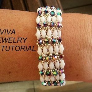 May include: A white and iridescent beaded bracelet with a gold clasp. The bracelet is on a person's wrist. The text "RD VIVA JEWELRY TUTORIAL" is visible in the image.