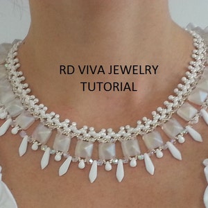 Pu&ograve; includere: Una collana di perle bianche con un design a strati che presenta perline quadrate e a forma di lacrima. La collana &egrave; indossata da una persona e il testo "RD VIVA JEWELRY TUTORIAL" &egrave; visibile nell'immagine.